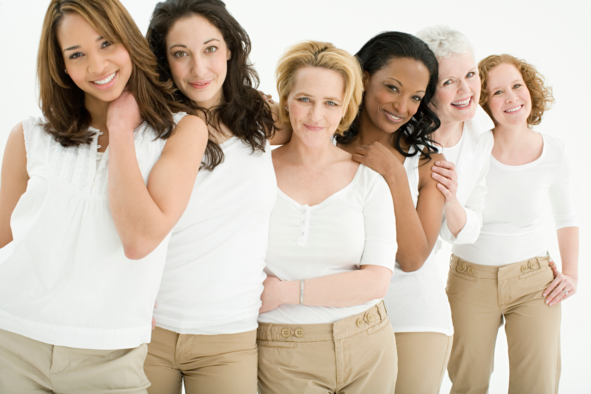 happy women, a cross section of ages, mainly middle aged. white tops and beige trousers